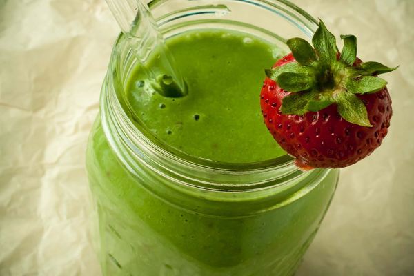 Green smoothie with a strawberry as garnish